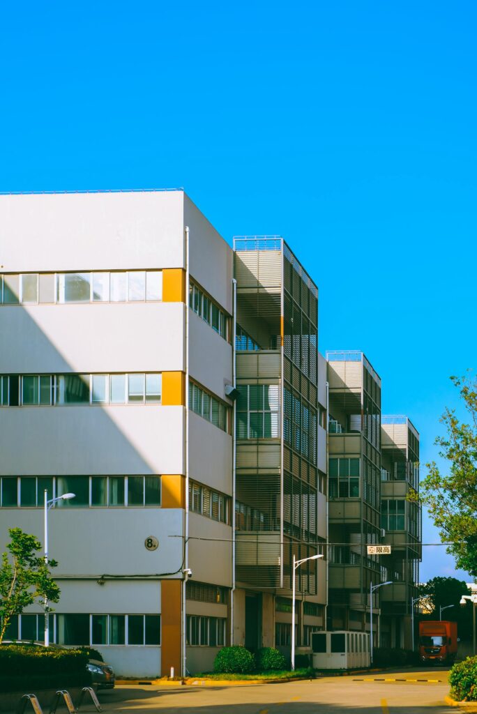 pexels-photo-33152525-33152525 Contemporary urban apartment building with blue sky backdrop, showcasing modern architecture.